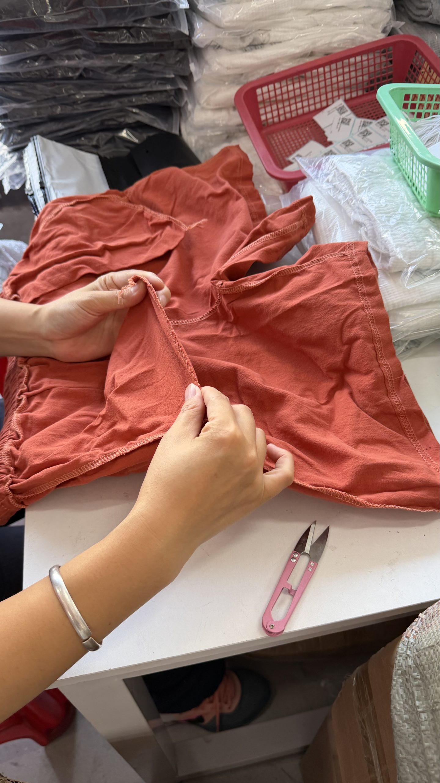 Trimming loose threads to prepare products for the brand
